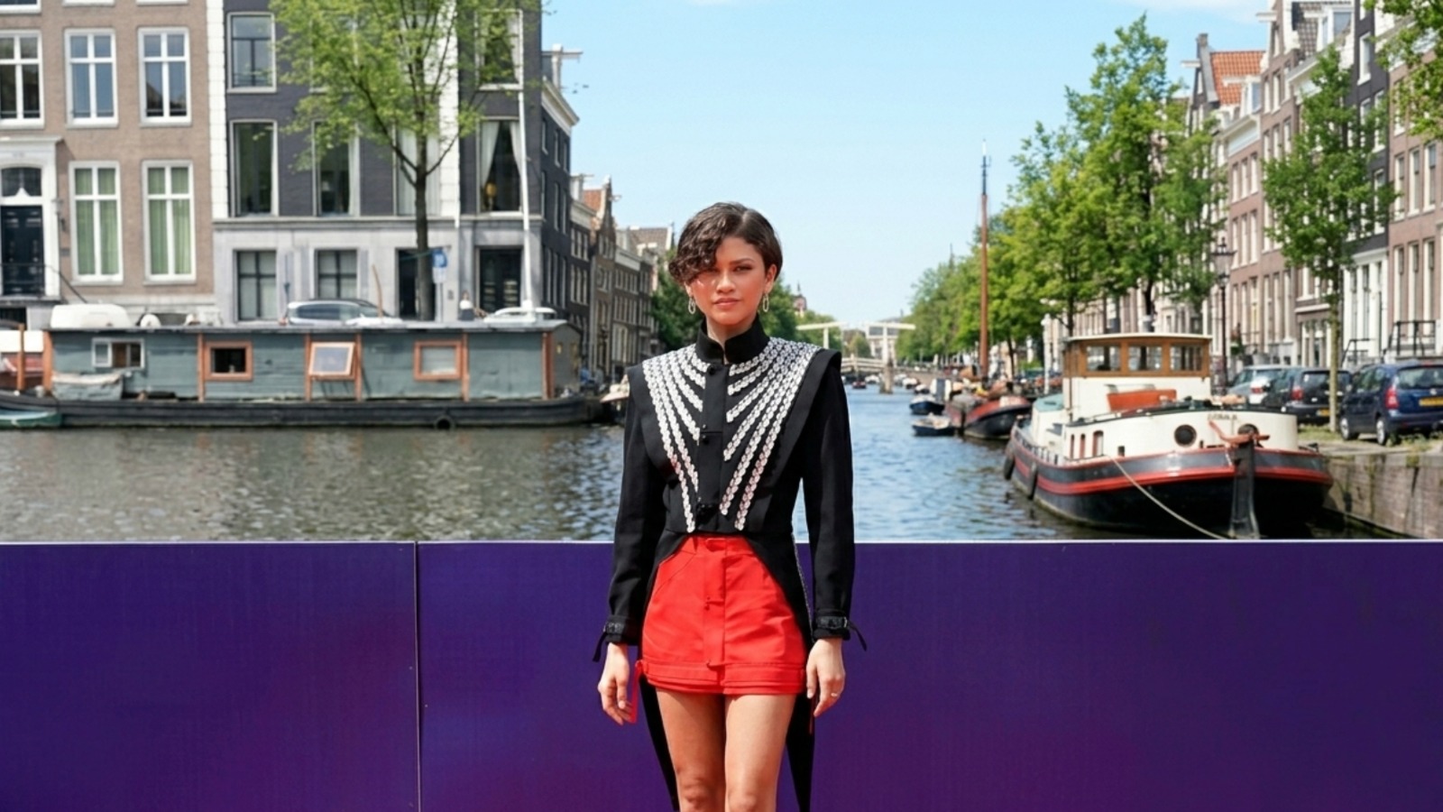 Zendaya Spider-Man Amsterdam premiere black hybrid tailcoat jacket with silver embroidered armor detailing, cropped front, and long sculpted back tails